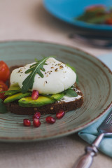 sandwich with avocado, poached egg, arugula and cherry tomatoes