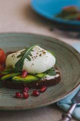 sandwich with avocado, poached egg, arugula and cherry tomatoes