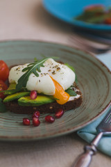sandwich with avocado, poached egg, arugula and cherry tomatoes