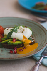 sandwich with avocado, poached egg, arugula and cherry tomatoes