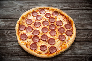 Pizza pepperoni on wooden table close up