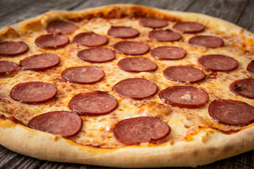Pizza pepperoni on wooden table close up