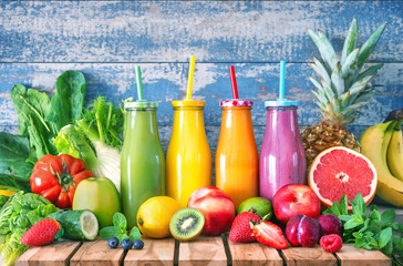 Colorful freshly squeezed fruits and vegetables smoothies with ingredients for healthy eating