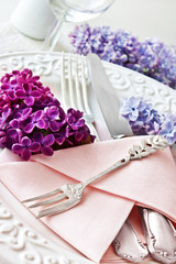 Springtime table decoration and lilac blossoms