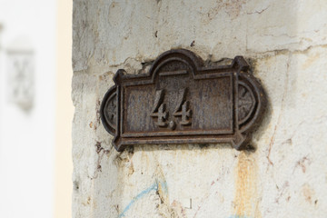 Rusty, corroded old metal door plaque with number 44