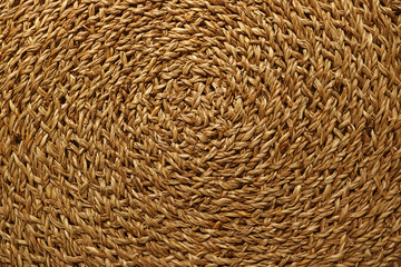 Artistic pattern of golden brown woven sedge place mat surface