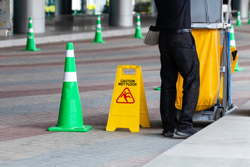 Caution wet floor signs, with Janitorial and mop bucket.
