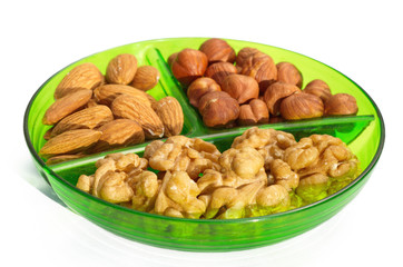 Nuts on a plate with sections on a white background 