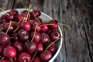 Bowl of fresh red cherries on wooden background - Image