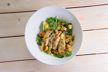 Spinach salad with boiled chicken breast, croutons sprinkled with rubbed Parmesan cheese
