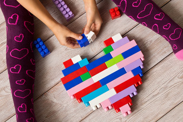 Multi-colored plastic constructor in the hands of the girl. Children's educational games