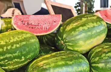 a lot of watermelon and cut half over with Plastic wrap in market.
