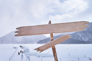 Wooden Sign with Igloo village in snowy winter season at Obhiro city, Japan.