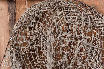 Old fishing nets hanging on wooden wall