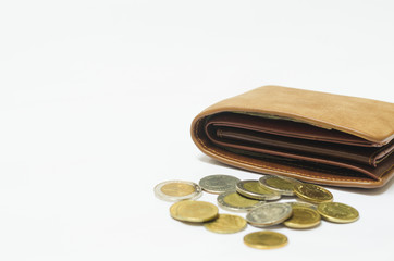wealth brown leather wallet on white background with many coin put in front of. wealth, saving, money, finance and investment concept.