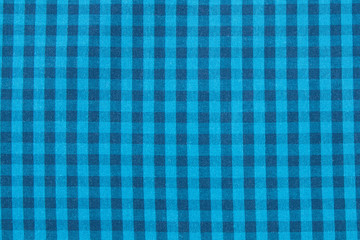 The background texture of the plaid fabric is blue. Abstract checkered background.