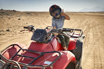 Kid in helmet and protect mask riding quad bike © Andriy Bezuglov