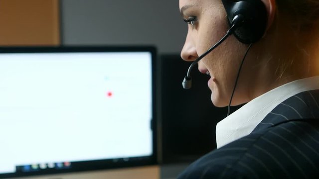 Call center operator answers the call and communicates with the client. Back view.
