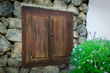 Wooden shutters on a backgroung of stone wall