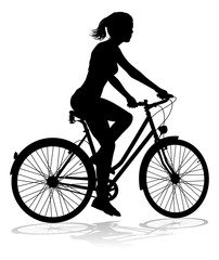 Obraz na płótnie Canvas A woman bicycle riding bike cyclist in silhouette