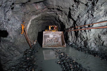 Underground gold ore mine shaft tunnel gallery passage with load, haul, dump machine LHD