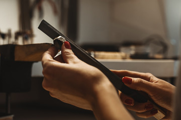 Delicate jewelry work. Close up of a female jeweler's hands working and shaping an unfinished ring...