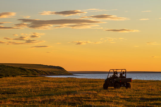 Utility terrain vehicle (UTV, quad bike or buggy car) in the tundra. Beautiful summer sunset in the extreme North. Off-road trip in the Arctic. Adventure tourism. Chukotka, Siberia, Far East of Russia