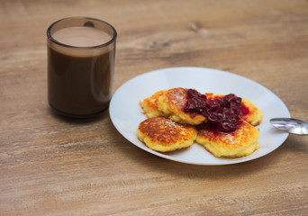 Cottage сheese pancakes with fried crust with with  coffee on wooden background