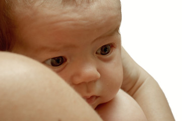Baby in the arms of his mother, a thoughtful look, close-up
