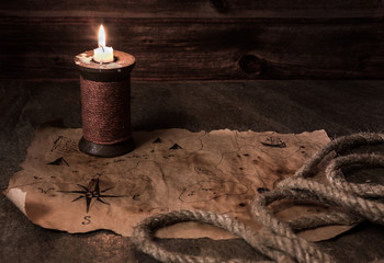 old pirate map on stone table, ancient candle, ship rope, pirate table