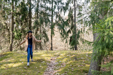 Obraz premium Beautiful girl in a coat runs through the woods. Happiness, freedom, zen concept