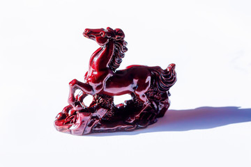 little ceramic statues of symbolic animals on white background, Horse sculpture.