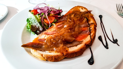 Bruschetta with stewed meat and vegetables lying on a plate