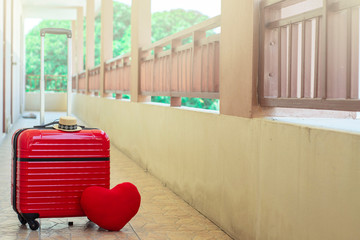 Fototapeta na wymiar Red luggage with red heart on blurred for activity lifestyle outdoors