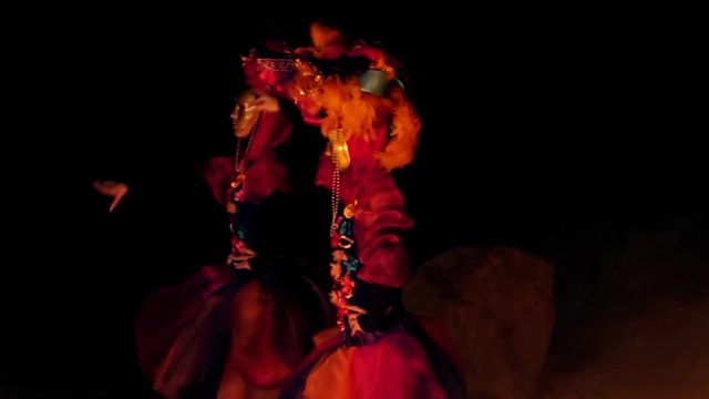 girls in carnival costumes dancing in front of the fire at night.