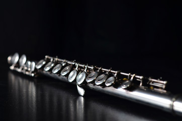 Glossy silver transverse flute on a black background