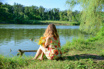 girl sitting on the edge of lake