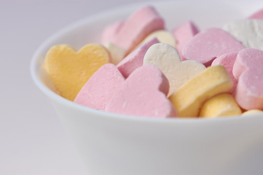 macro color picture of candy hearts in a white bowl