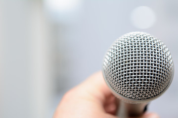 Obraz premium studio microphone on a blurred background in male hand