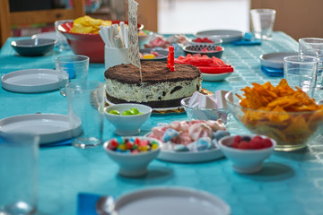 Colorful sweets on birthday table with blue tablecloth
