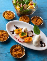 Roasted vegetable, circle pastry on blue table.