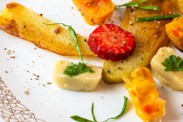 Roasted vegetable pieces with strawberry.