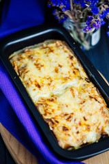 meat cheese pie in baking dish on a dark wooden background