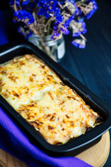 meat cheese pie in baking dish on a dark wooden background