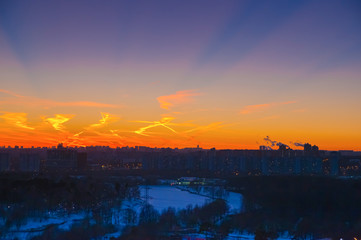 Obraz premium Orange clouds with aircraft trails sky background and city light midnight evening time