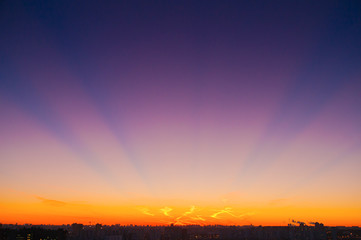 Orange clouds with aircraft trails sky background and city light midnight evening time