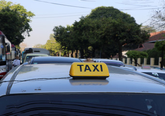 Taxi light sign or cab sign in yellow color with black text on the car roof.