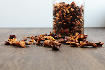 Jar of Dried fruit scattered on a wooden table