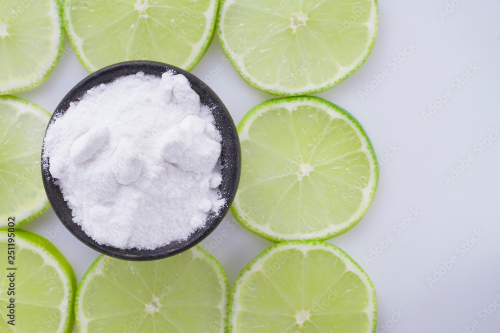 Wall mural baking soda and slices of lemon on white background