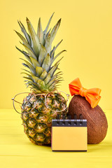 Exotic fruits and paper notepad. Summer background with pineapple, coconut and blank binder...